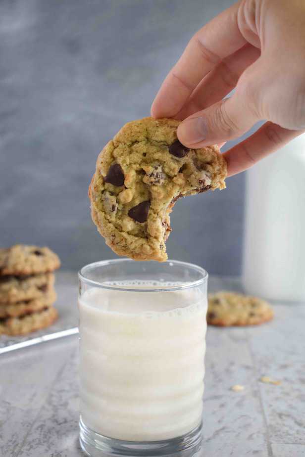 cookie with bite out of it about to get dunked into milk