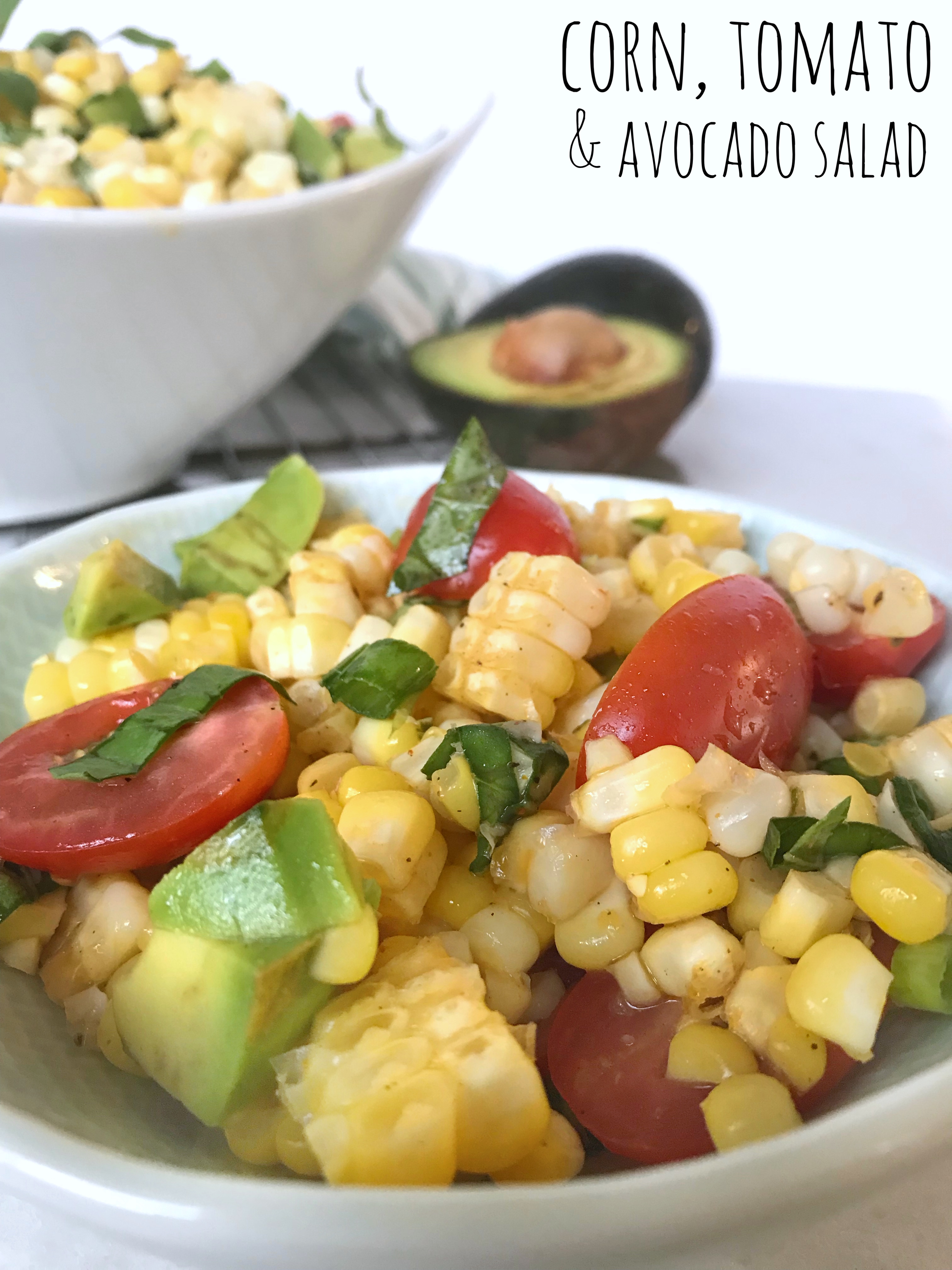 summer salad with corn, tomato and avocado in a large white bowl