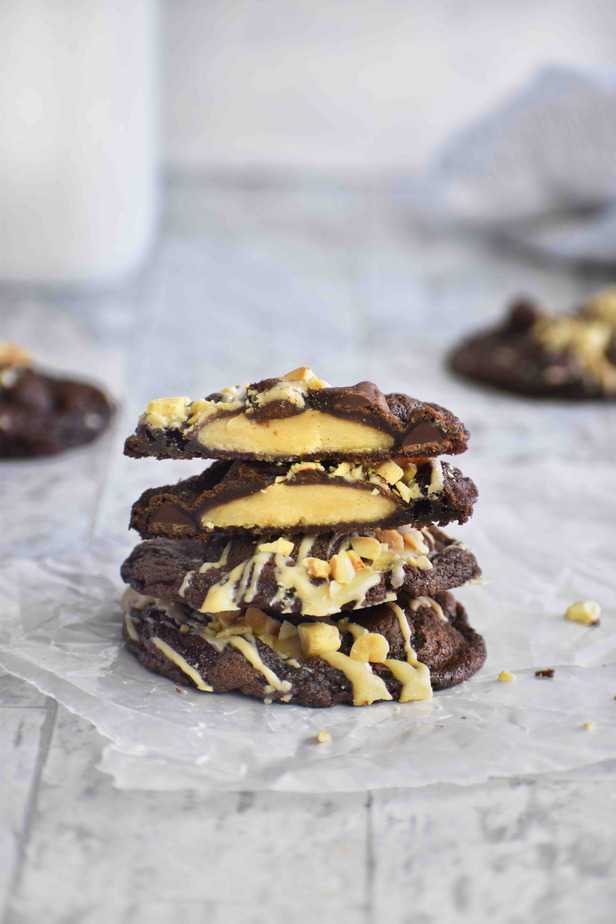 peanut double chocolate cookies cut in half showing peanut butter filling, stacked on two whole cookies