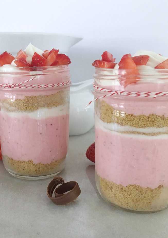 2 jars of strawberry mousse parfait with diced strawberries on top.