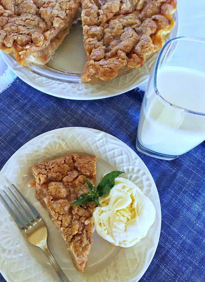 Brown Bag Apple pie on white plate with ice cream and whole pie with missing piece