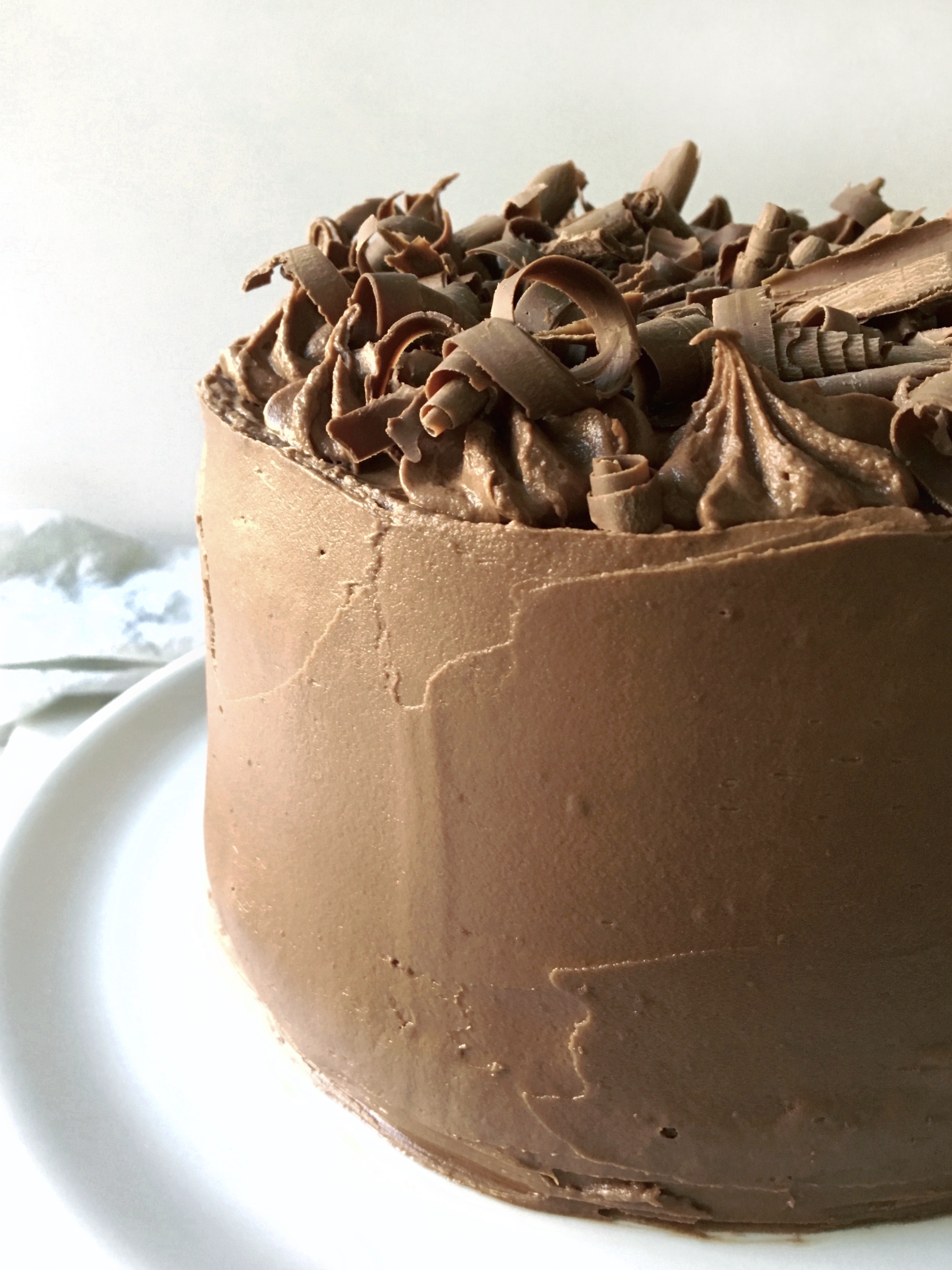 chocolate fudge frosting spread over a 3 layer cake