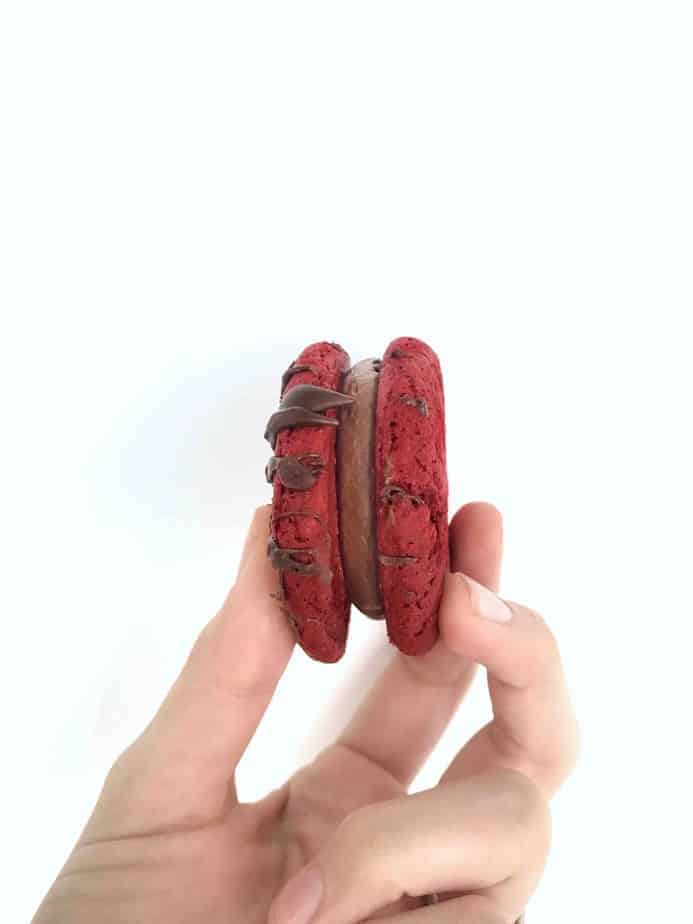 hand holding single red velvet cookie 