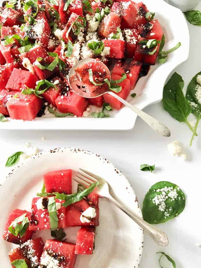 watermelon, feta, basil salad on white platter and salad plate