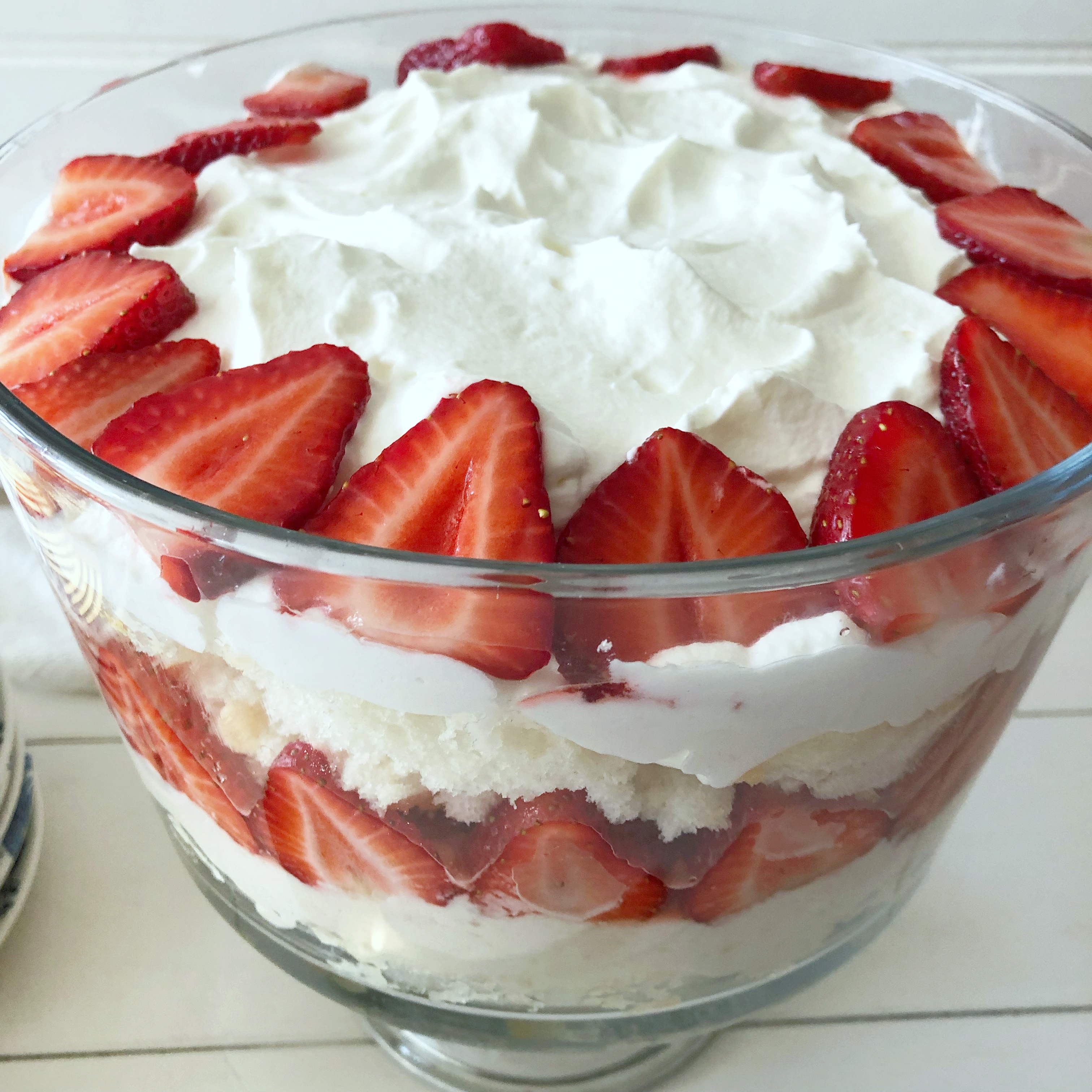 strawberry lemon trifle layered in a footed glass bowl 