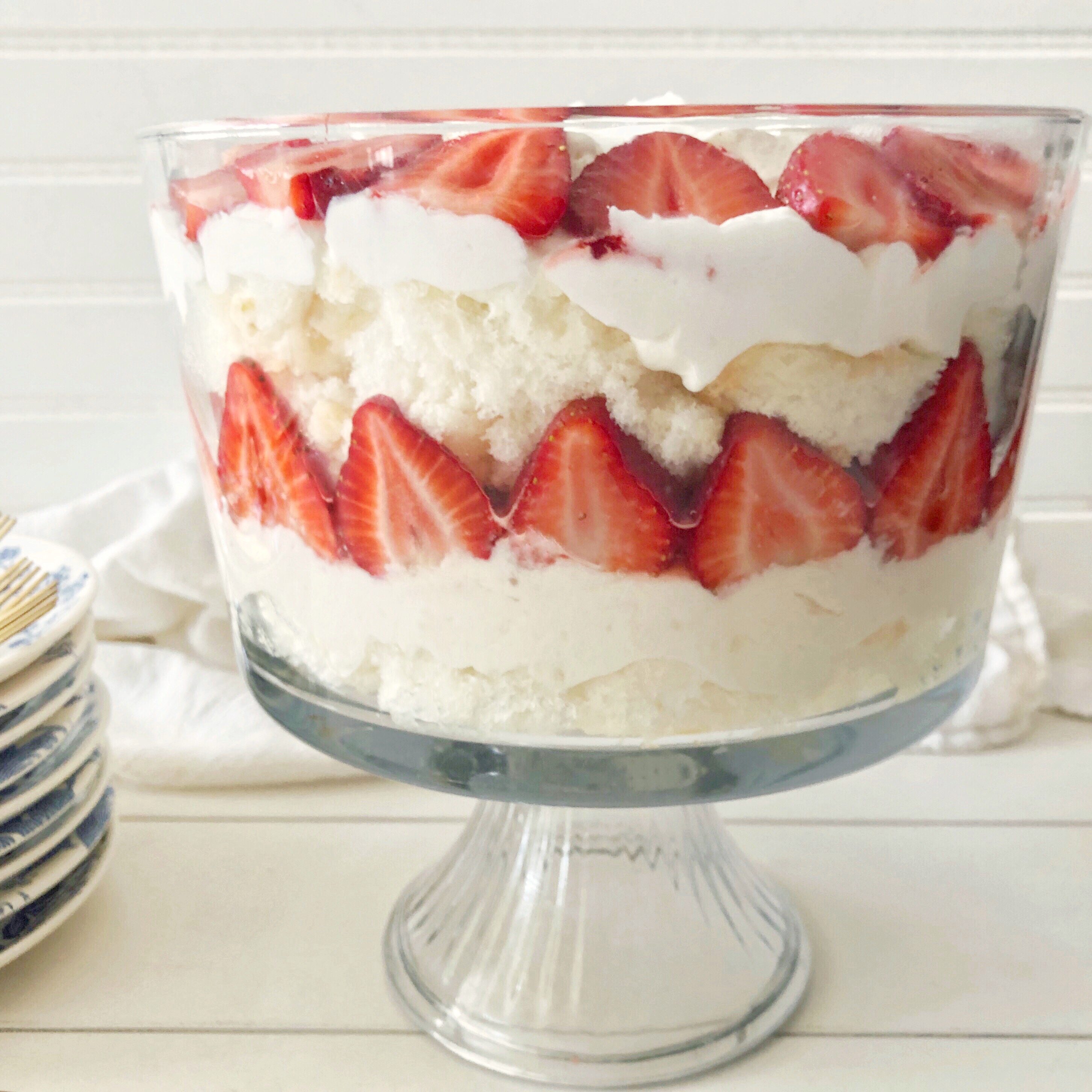 strawberry lemon trifle layered in a footed glass bowl 