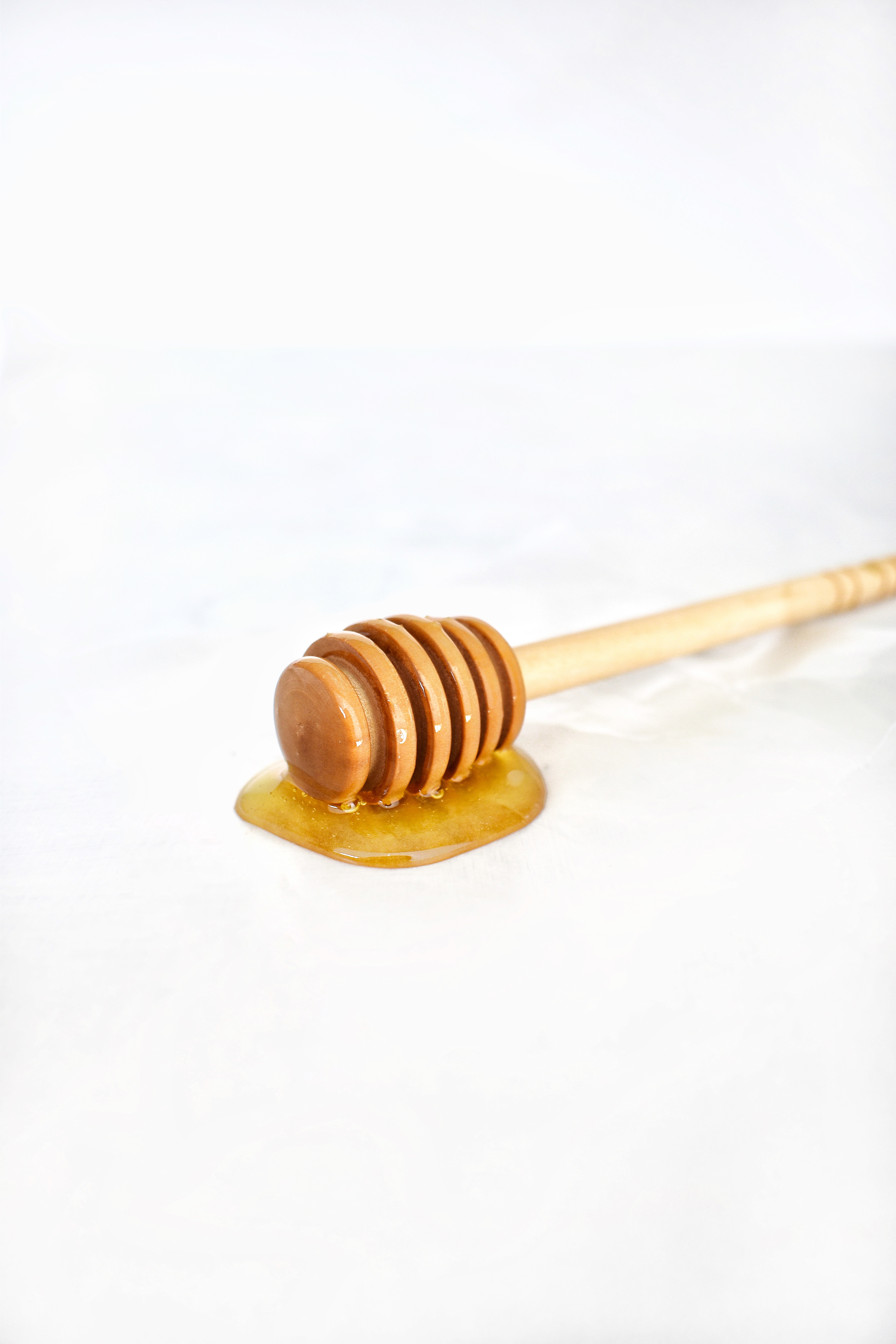 wand of honey sitting on a white background 