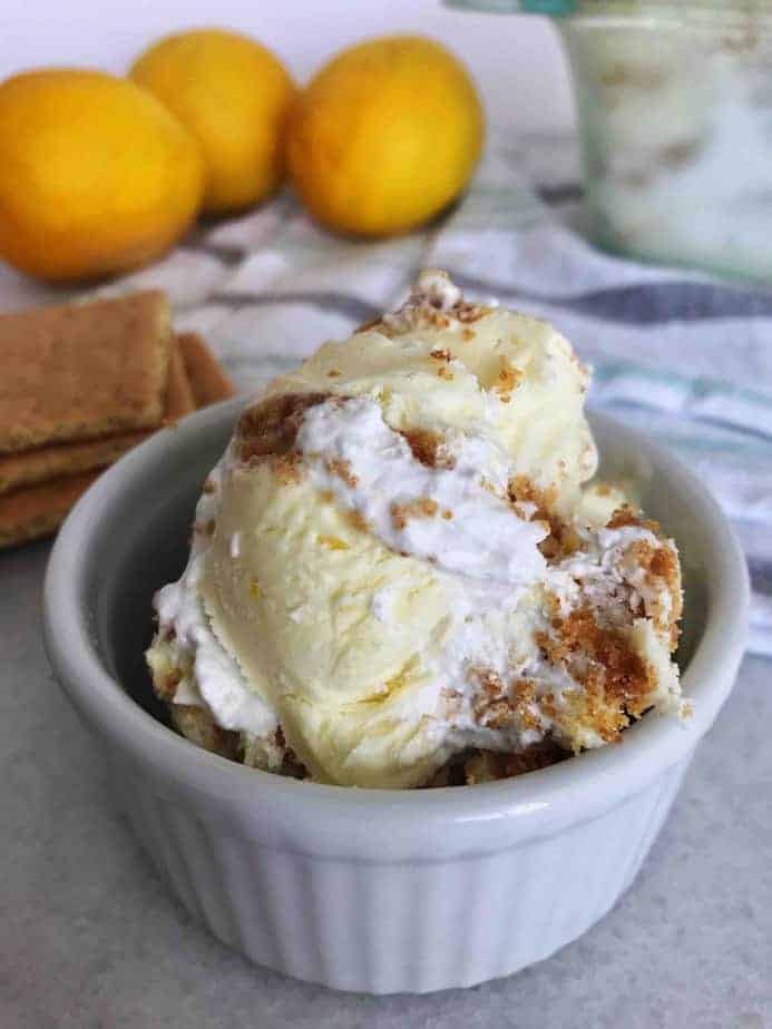 bowlful of lemon meringue pie ice cream with lemons in background