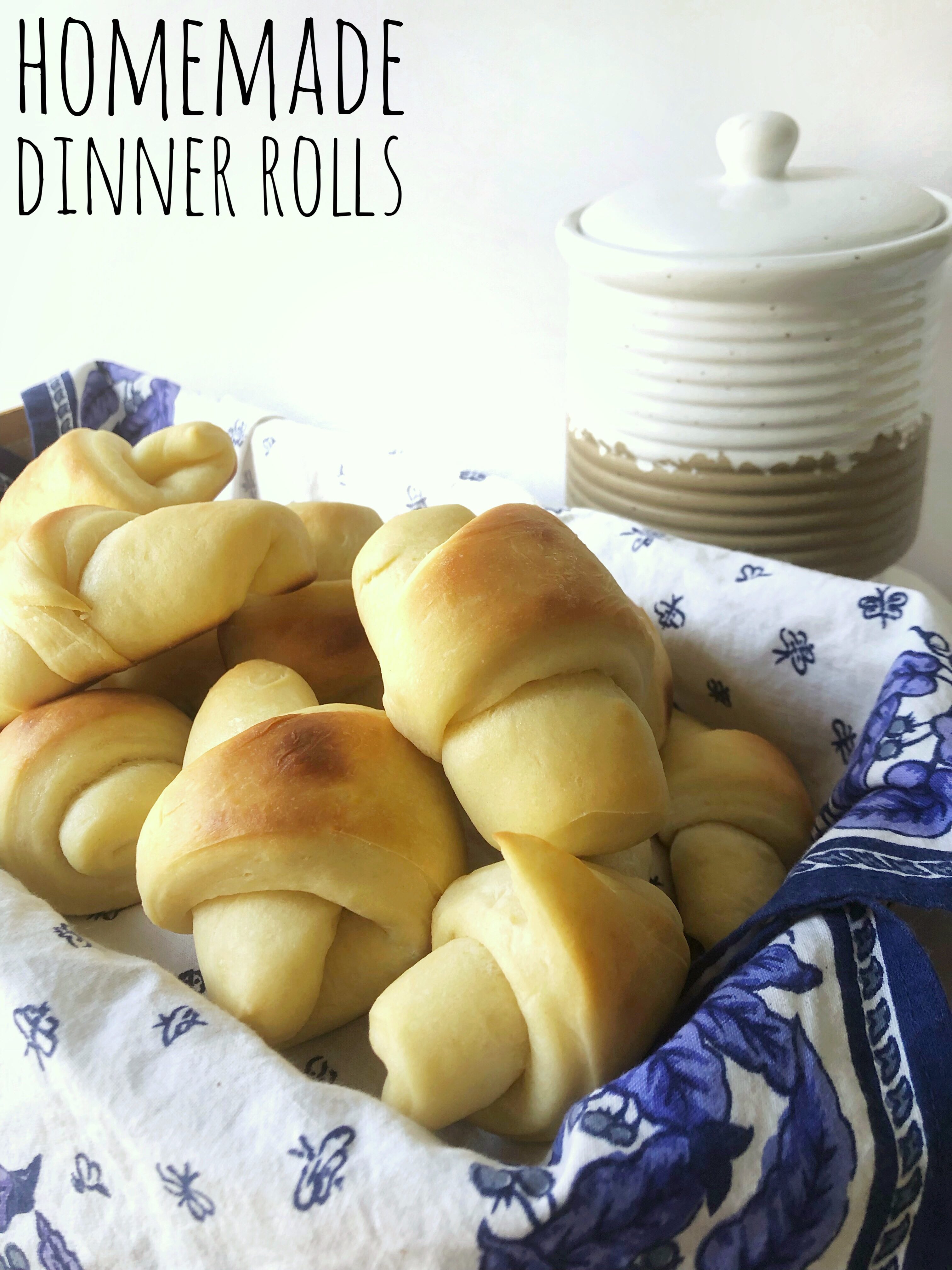 basket of homemade dinner rolls with blue and white napkin. Title.