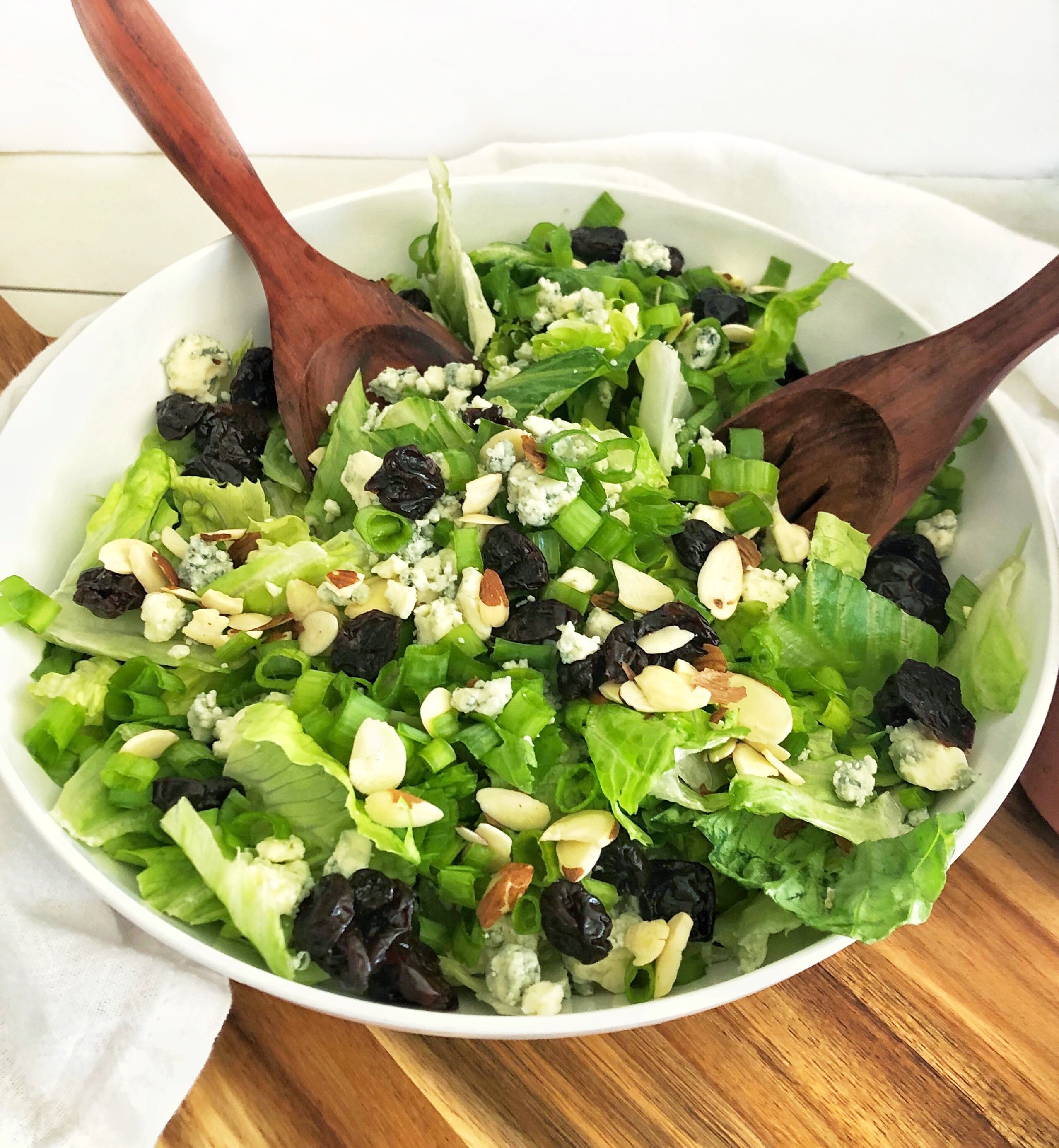 large white bowl of Romaine with cherry, gorgonzola and almond salad