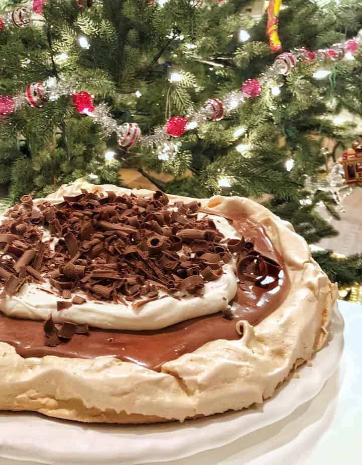 chocolate meringue torte sits in front of Christmas tree
