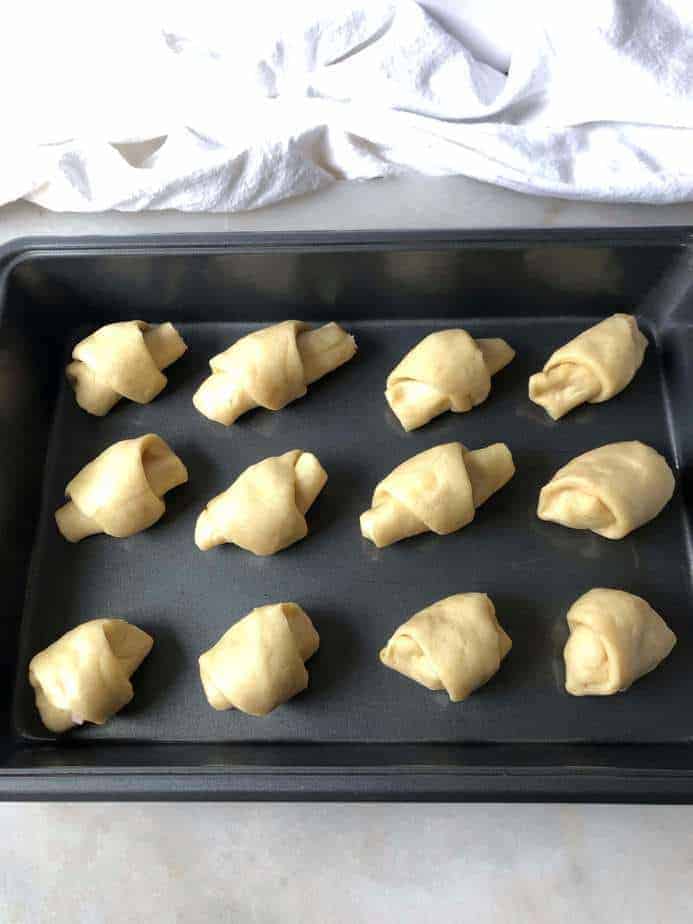 baking sheet with ham and cheese rolls ready to bake