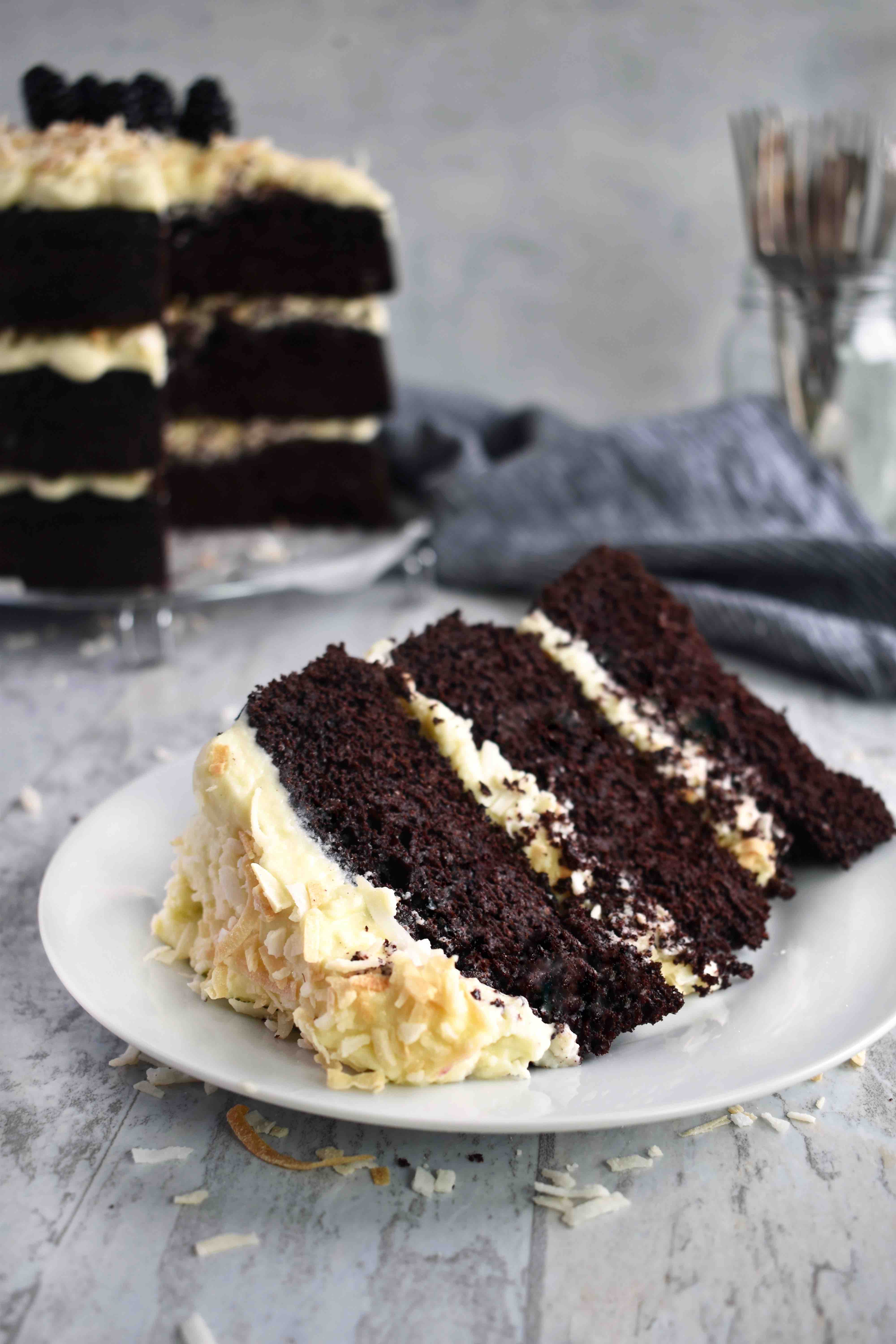 slice of chocolate coconut torte cake with full cake in background