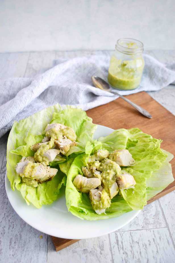 chicken salad in lettuce wraps with avocado dressing over top
