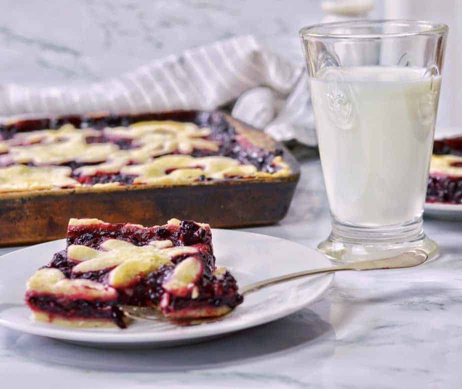 slice and whole pan of Triple Berry Slab pie with milk