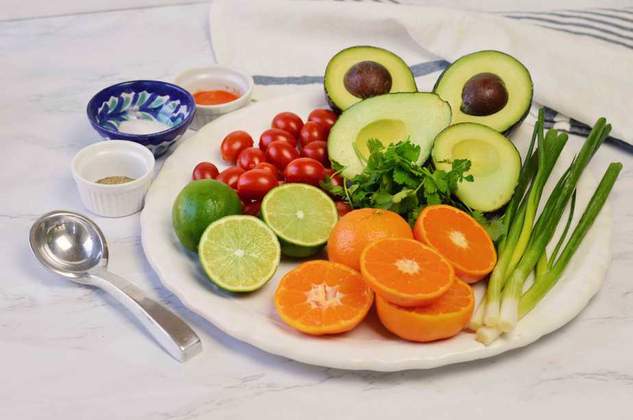 white platter of fresh ingredients for mandarin guacamole