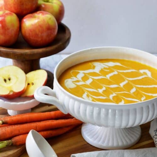 White bowl of apple carrot soup.