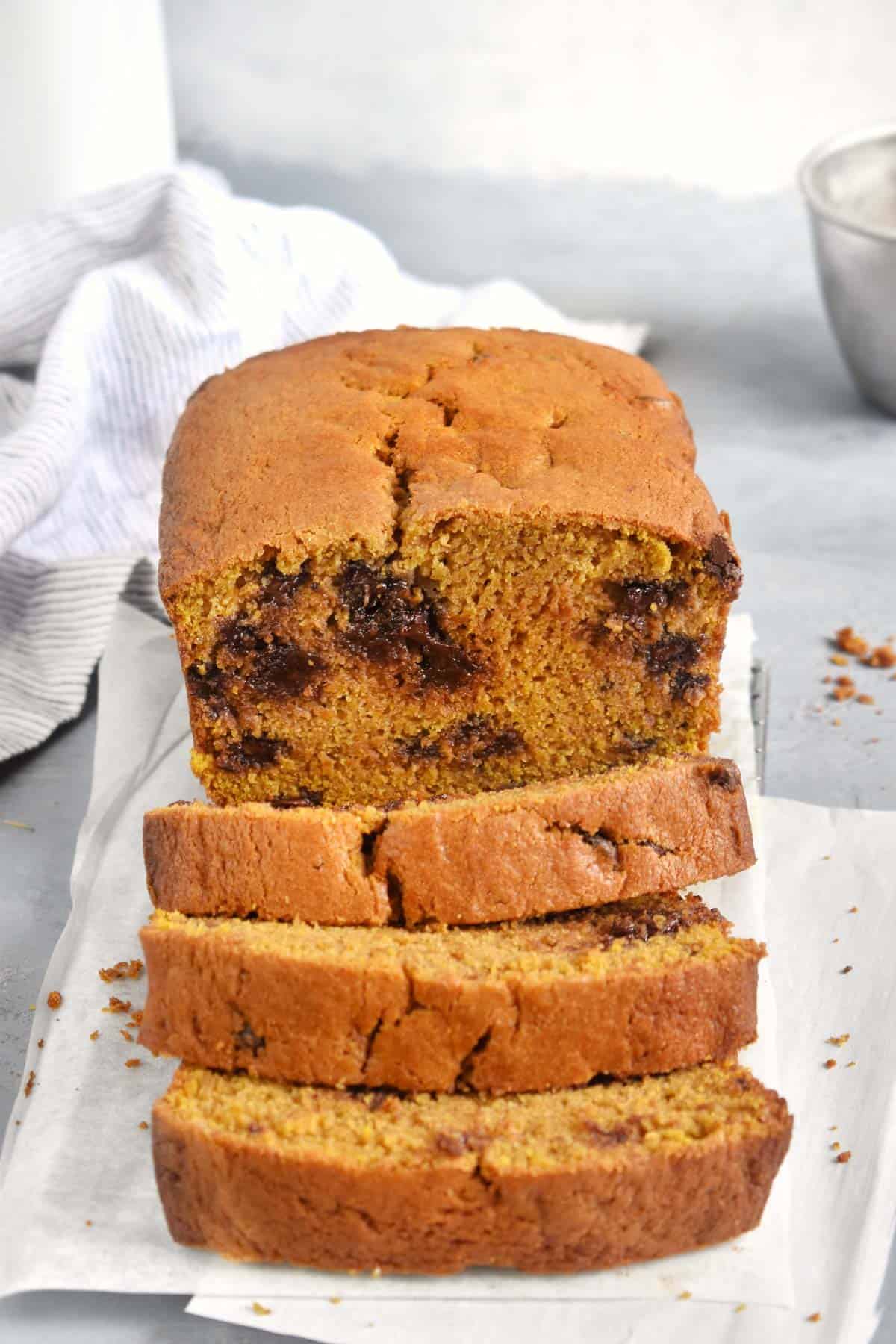 sliced pumpkin chocolate chip bread with white dish towel