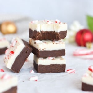 three squares of peppermint bark fudge stack on top of each other.