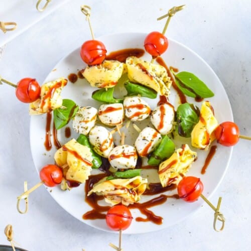 caprese skewers on white plate.