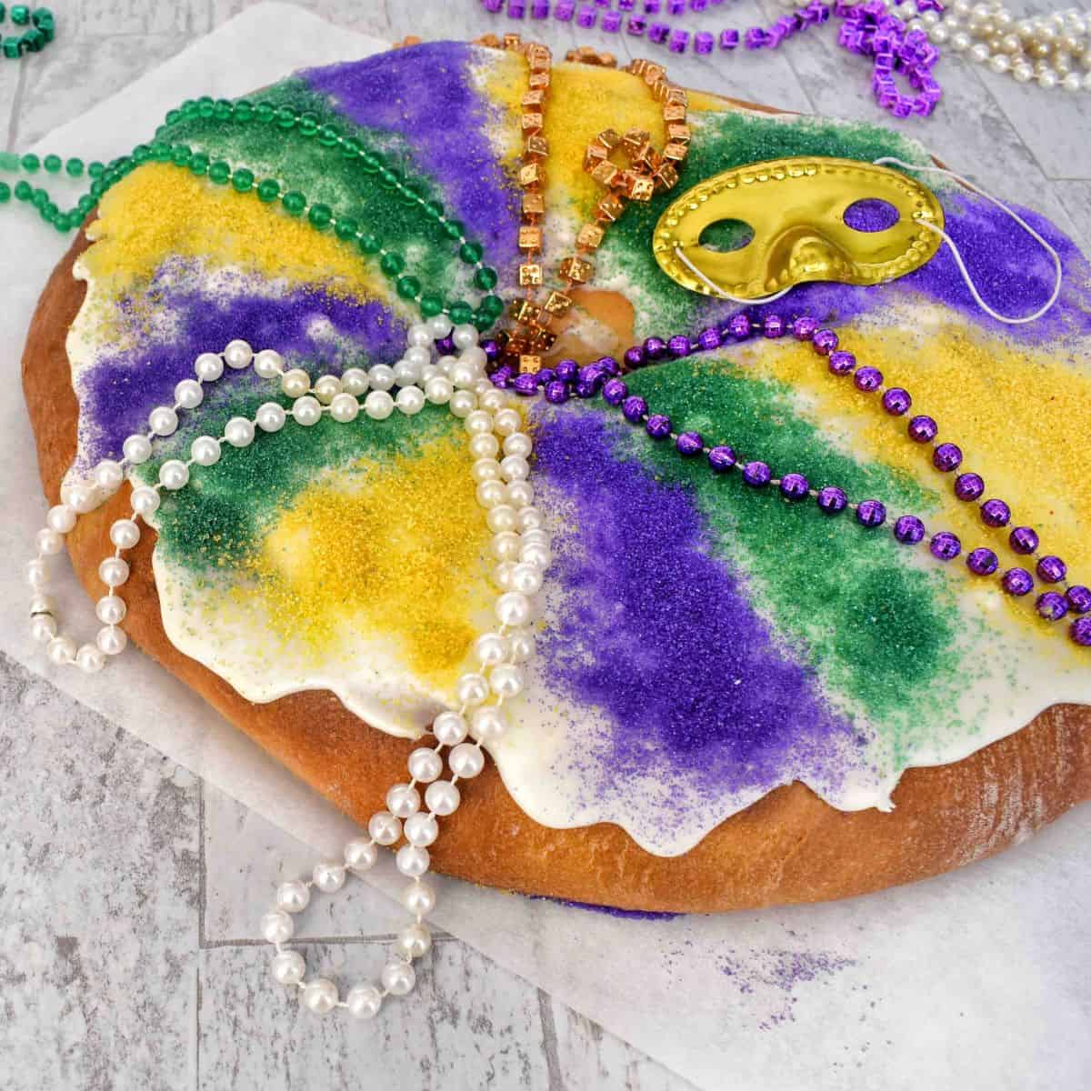 full king cake with beads on top.