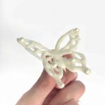 hand holding piped white chocolate butterfly