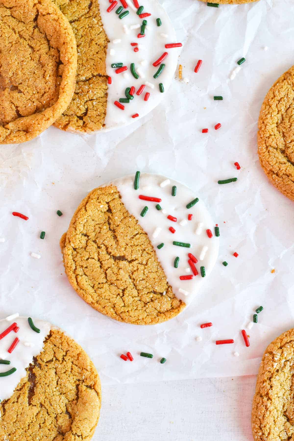 molasses cookie dipped in white chocolate with holiday sprinkles.