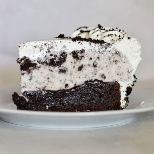 slice of cookies and cream brownie ice cream cake on plate.