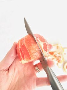 slicing in between segments of the grapefruit