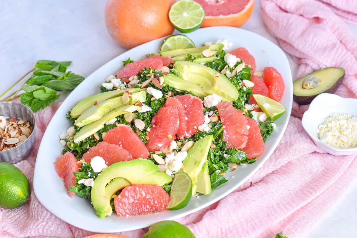 grapefruit mint kale salad on white platter.