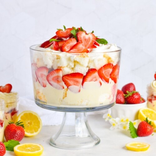 strawberry trifle layered with lemon mousse and angel food cake in glass trifle bowl.