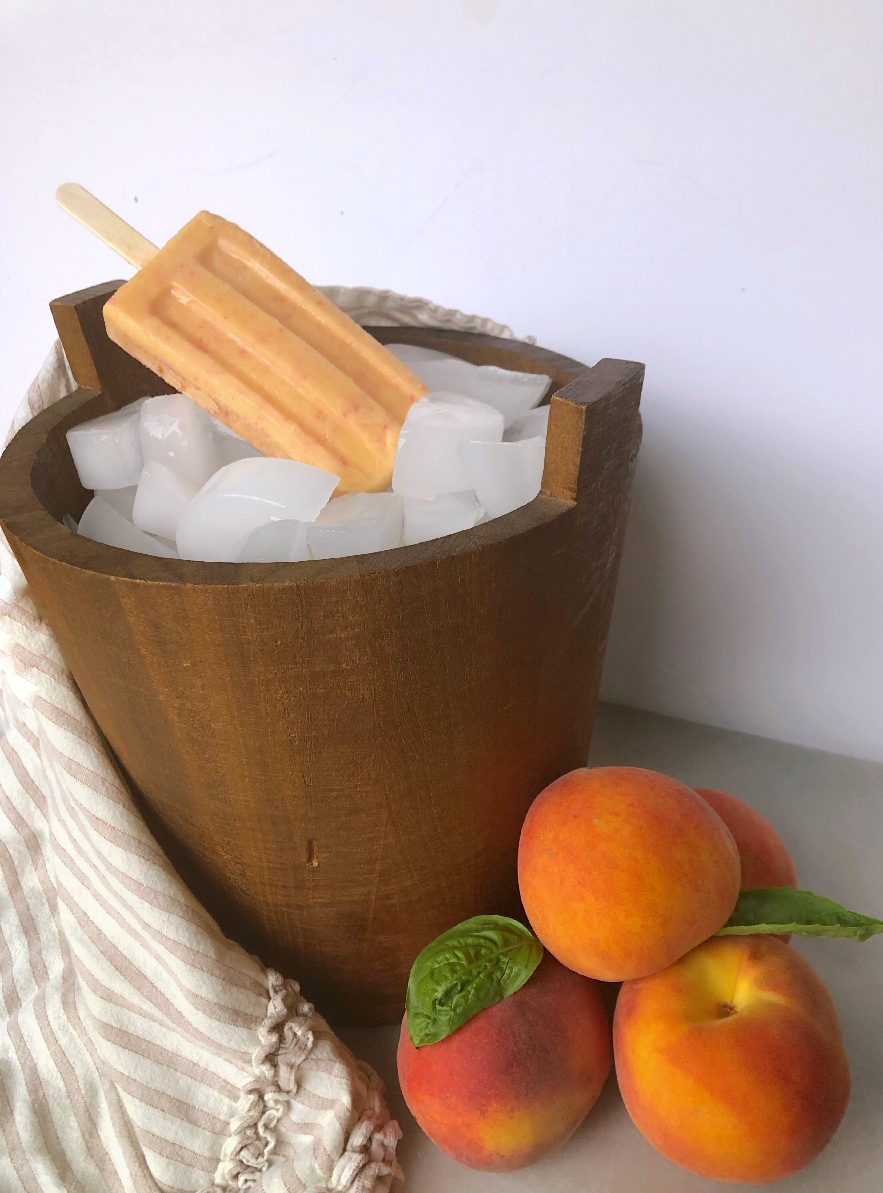 fresh peaches and cream popsicle in wooden barrel