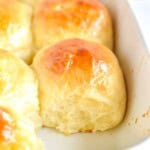 brioche dinner roll in white pan.