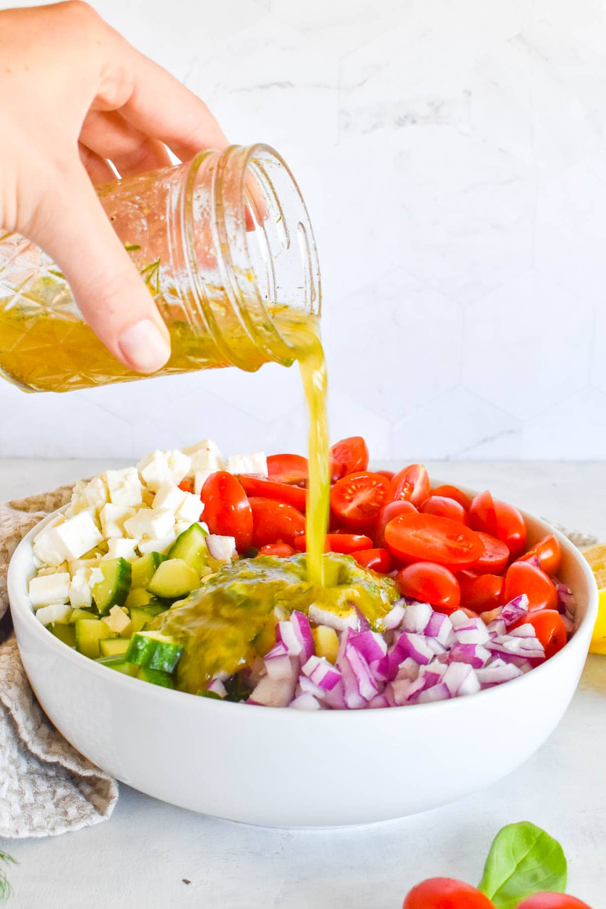 dressing being poured over top of salad.