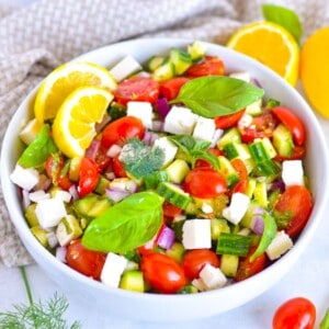 cucumber and tomato mediterranean salad in white bowl.