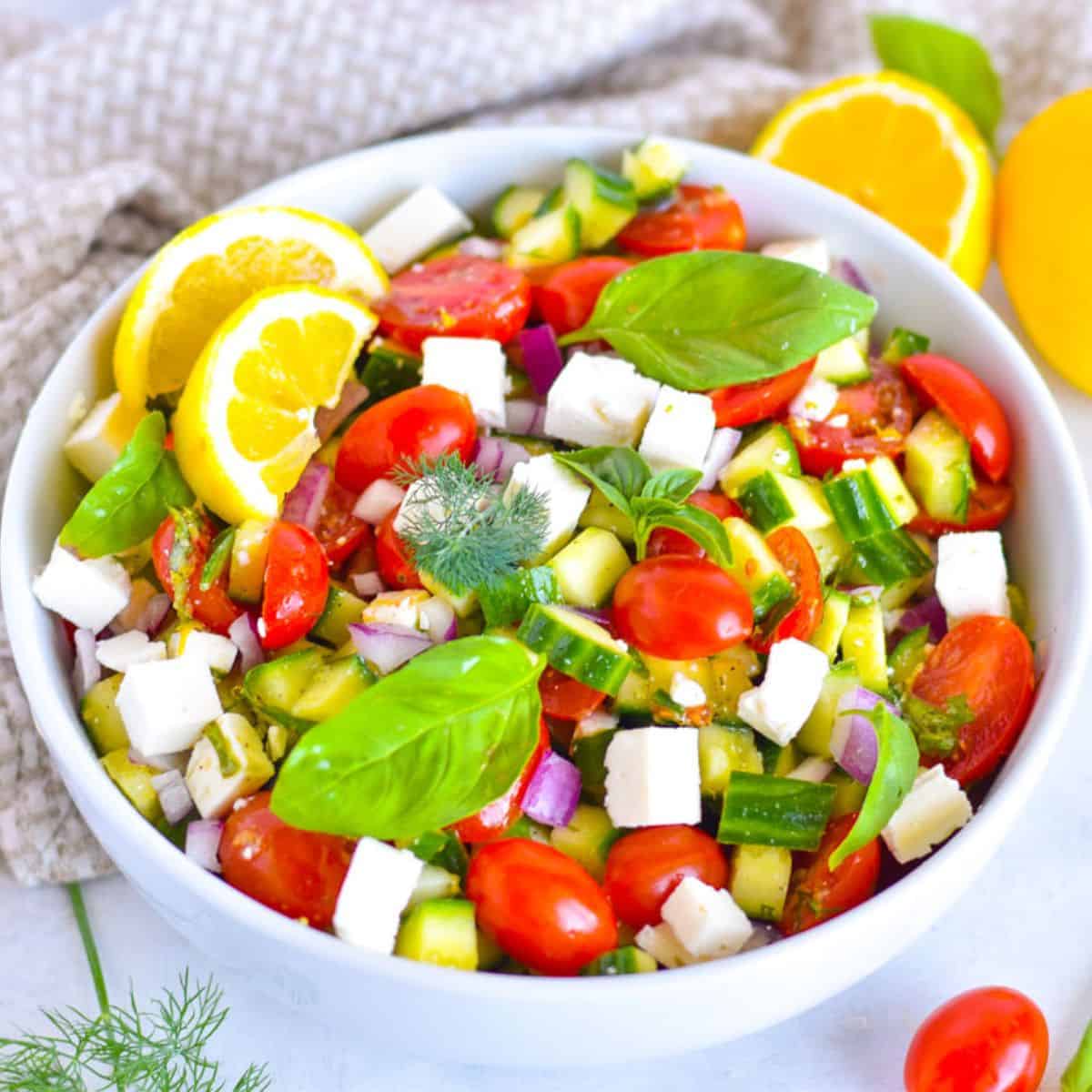 cucumber and tomato mediterranean salad in white bowl.