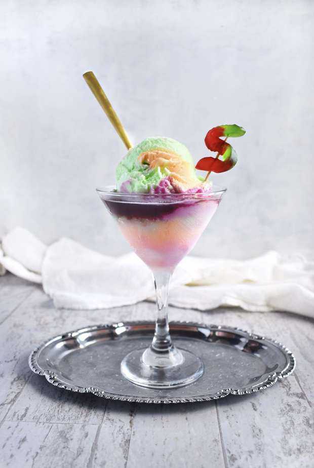 rainbow sherbet ice cream float in a martini glass on a silver tray