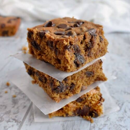 3 chocolate chip pumpkin blondies stack on top of each other.