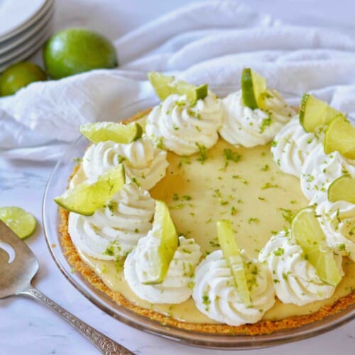 key lime pie w pie server and stack of plates