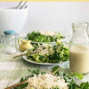 Sensation salad dressed with lemon garlic vinaigrette plated on three white plates with dressing bottle.