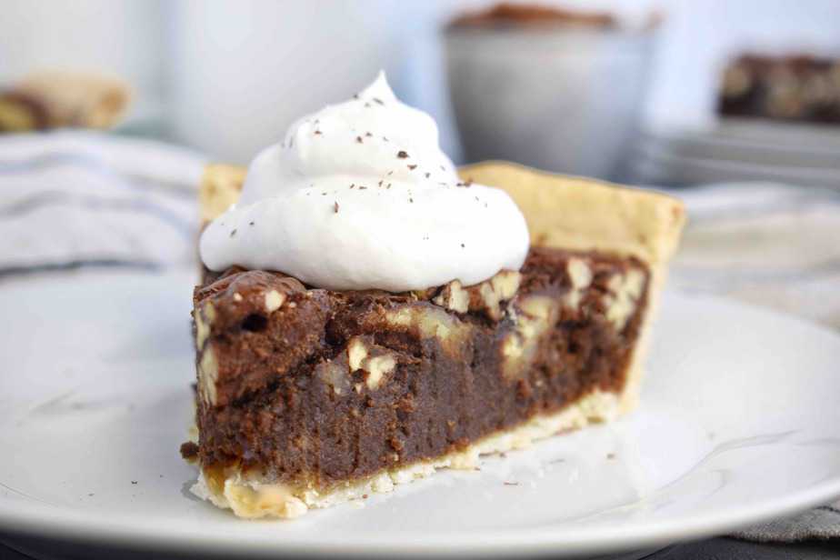 slice of chocolate pecan pie with whipped cream on top