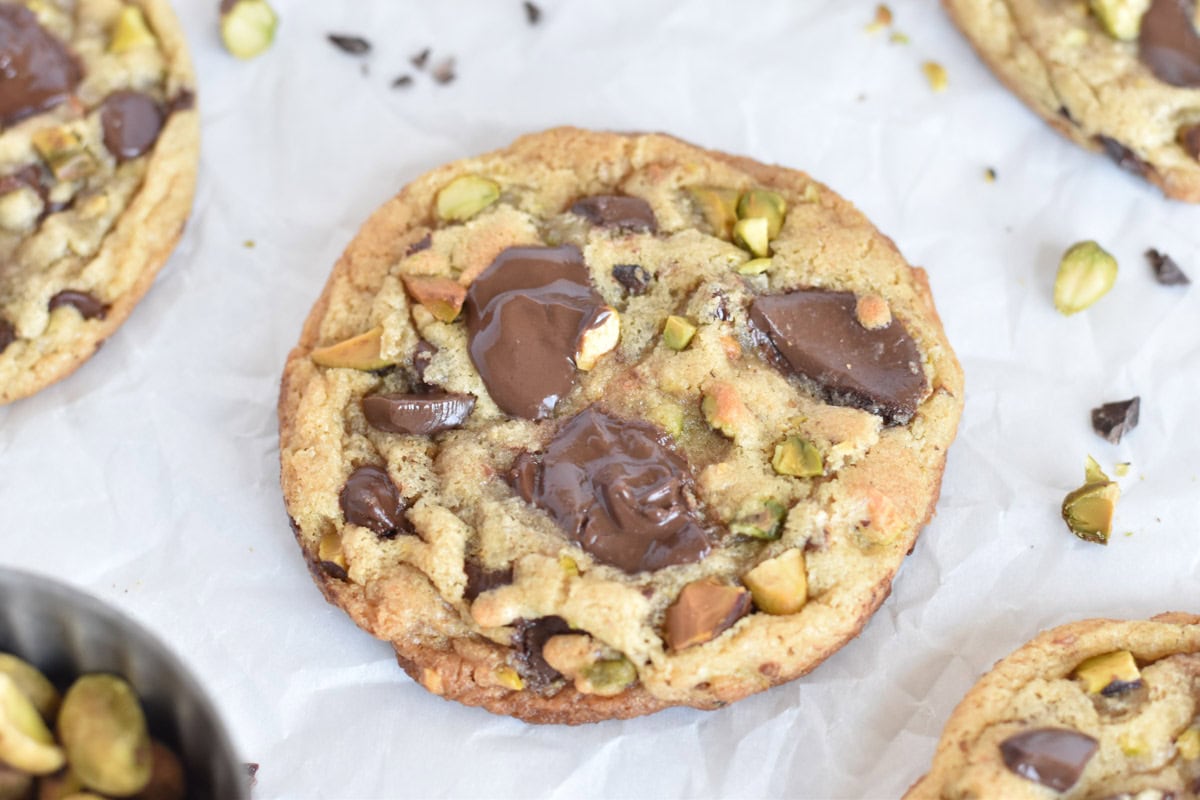 dark chocolate pistachio cookie on white parchment paper.