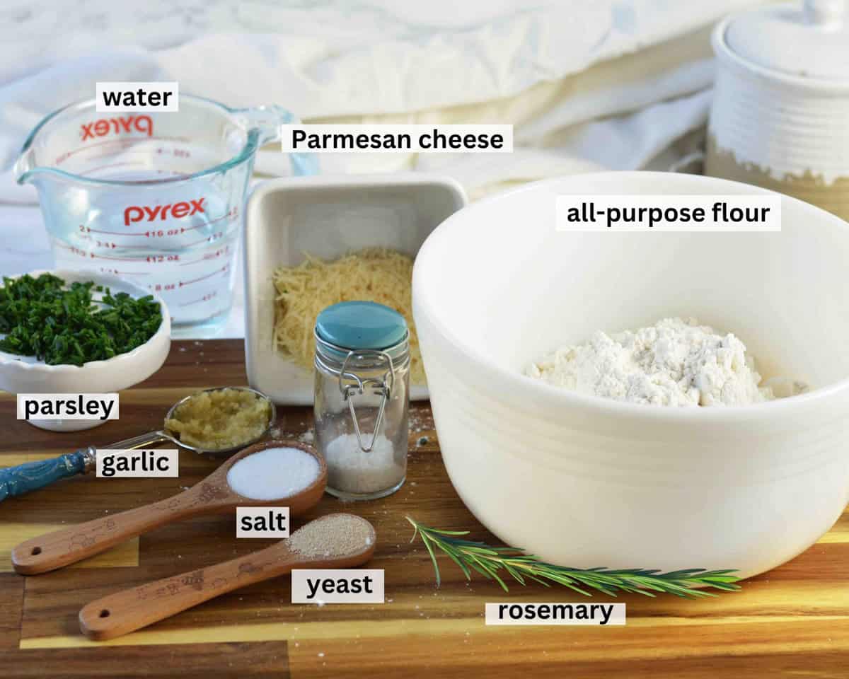 Ingredients laid out on cutting board to make herb artisan bread recipe.