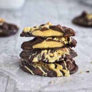 Stack of peanut butter cup cookies with chocolate and white chocolate drizzle.