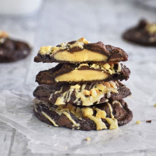 Stack of peanut butter cup cookies with chocolate and white chocolate drizzle.