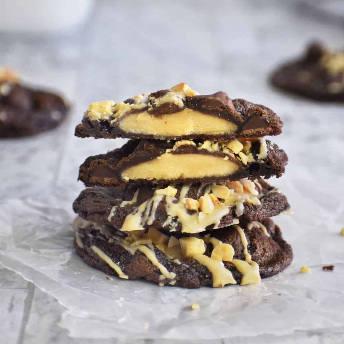 Stack of peanut butter cup cookies with chocolate and white chocolate drizzle.