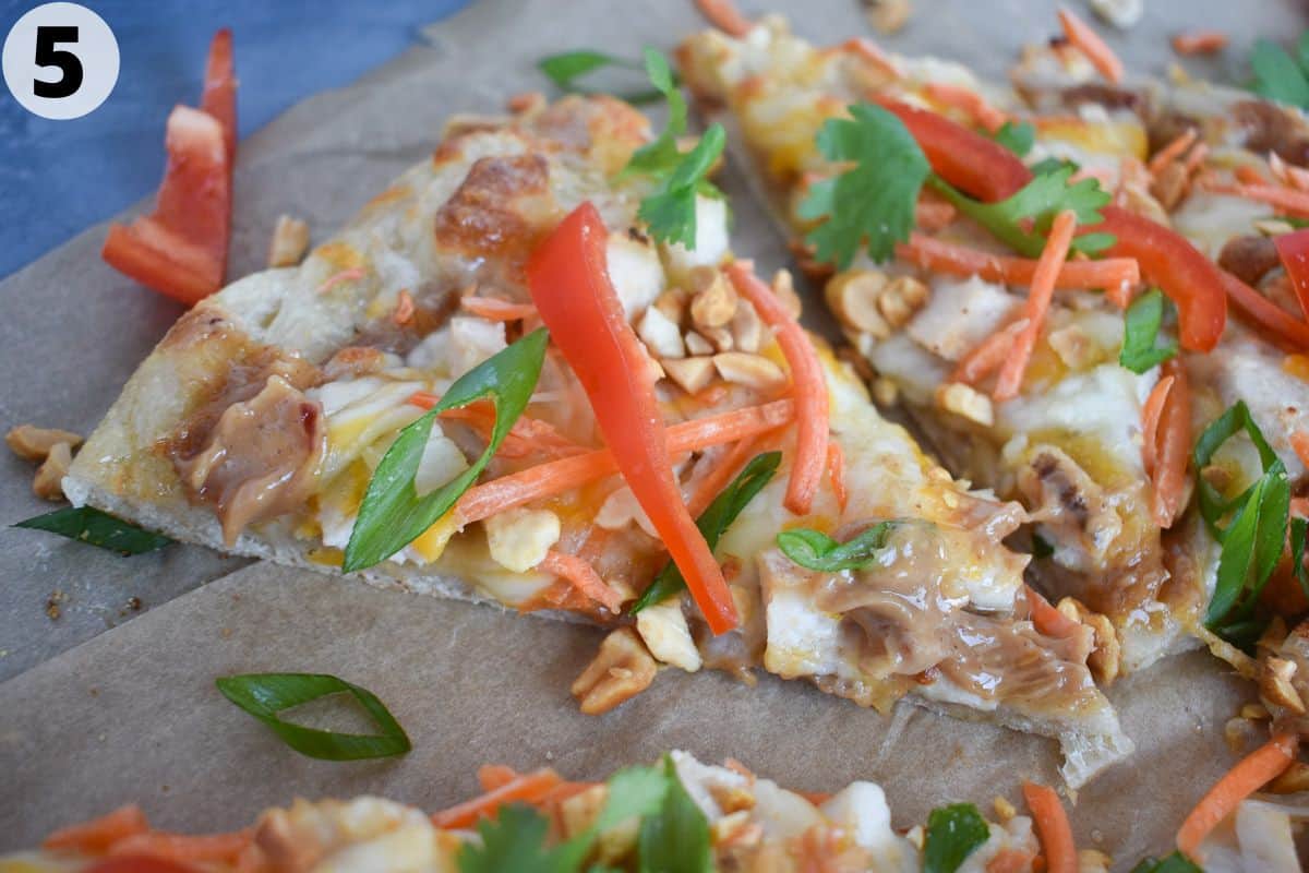 slice of thai pizza on parchment paper. 