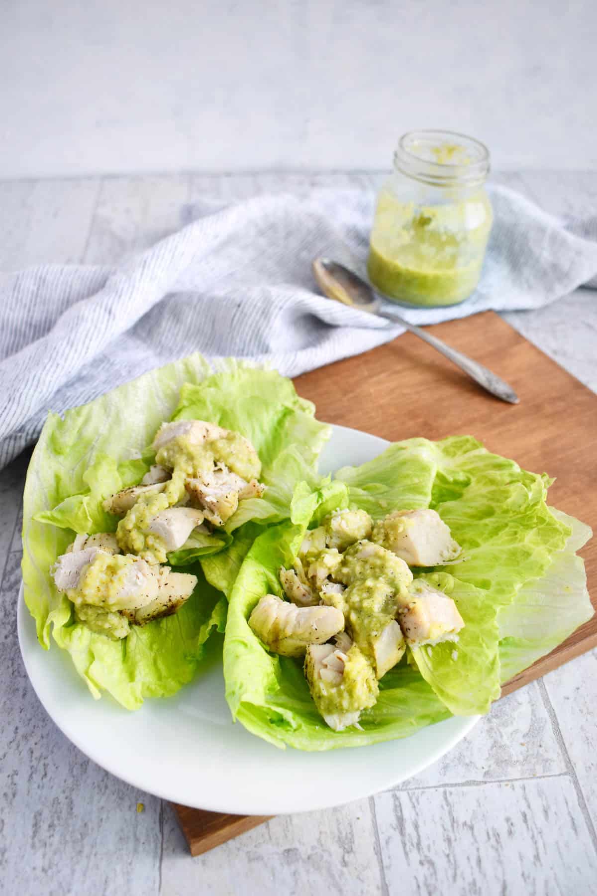 chicken lettuce wraps with avocado caesar dressing on top. 