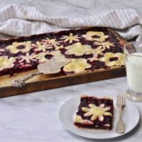slice of triple berry slab pie with fork and glass of milk