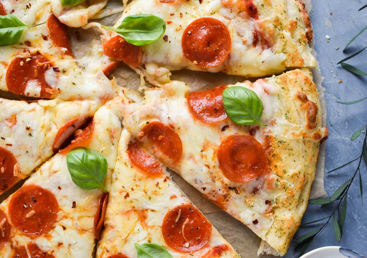 sliced pizza dough with basil on top. 